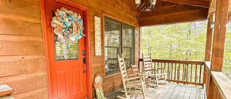 Front door and covered porch with rocking chairs for three