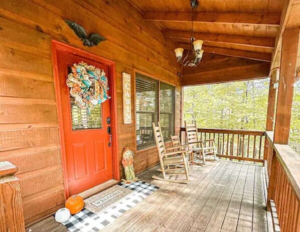 Front door and covered porch with rocking chairs for three
