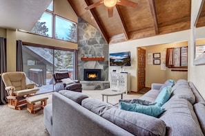 Open living area with fireplace, Smart TV, board games, and deck access