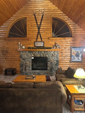 Large living room,  with soaring ceilings and beautiful stone fireplace.