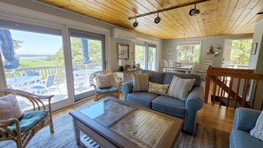 Living room has comfortable furniture and water views