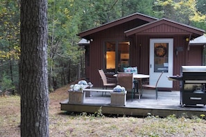 Cabin entrance with table and BBQ.