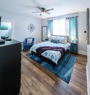 Master bedroom and seating area with Roku TV, extra pillows and blankets.  