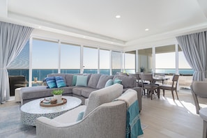 The living room with its wrap around sofas, long dining table, and enviable views.