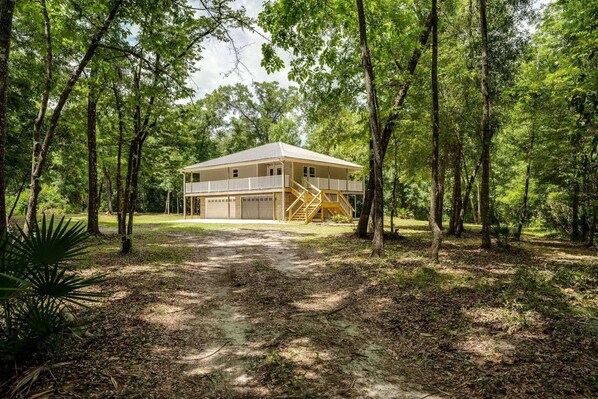 Exterior Retreat: Embrace nature from your spacious wraparound porch among the trees!
