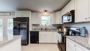 Fully equipped kitchen includes a large refrigerator with ice-maker. 