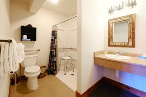 This thoughtfully designed ensuite bathroom features grab rails and a built-in shower chair for enhanced accessibility. The spacious layout ensures comfort and ease of use, with modern fixtures and a walk-in shower for a relaxing experience.