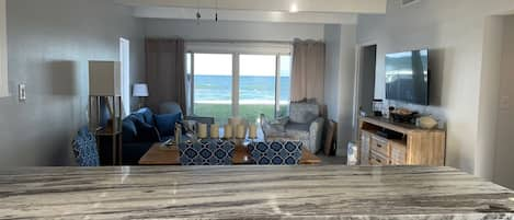 From the kitchen looking through the living room out to beach and ocean.