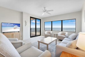 Living room offering water and beach views. 