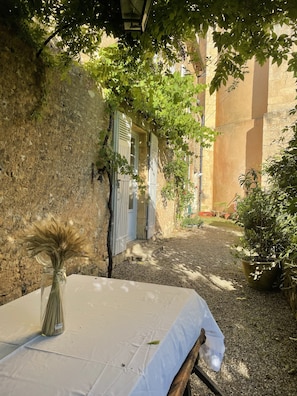 Terrasse sous la glycine, sur jardin à l’ombre