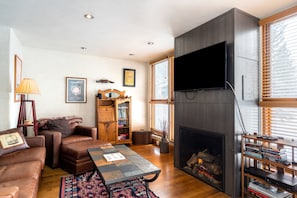 Living room features comfortable seating and a fireplace.