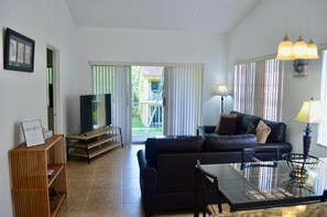 Dining area and living room with access to private balcony overlooking courtyard