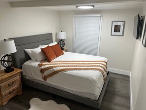 Bedroom 1 - Queen bed, closet, luggage rack, and Smart TV