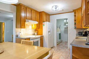 The kitchen leads into the laundry room