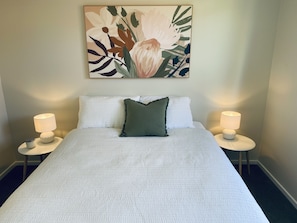 Master bedroom features a plush queen sized bed and luxurious linen