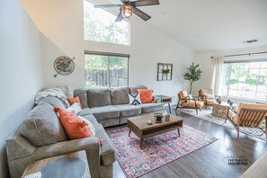 Bright, Spacious Living Room for Gathering Enjoy a bright, open living room with high ceilings, comfortable seating, and a modern design. Perfect for connecting with loved ones or relaxing in style.