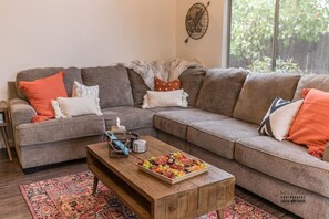Cozy Living Room with Oversized Sectional Relax in a spacious living room with a large, plush sectional, warm decor, and natural light—a perfect spot to unwind after exploring or enjoying family movie nights.