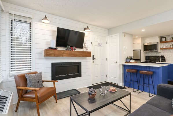 Updated living room area with electric fireplace and flat screen tv.