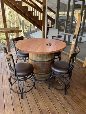 Covered deck with TV and plenty of seating around the whiskey barrel bar area.