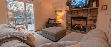 The bright living room is a cozy place to snuggle up by the fire