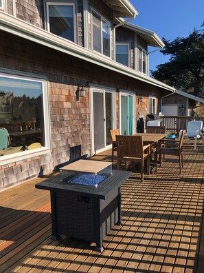 Sprawling wrap-around back deck with dining space and firepit. 