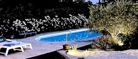 Le jardin méditerraneen qui mène à la piscine, à la tombée de la nuit