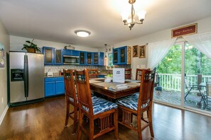 The heart of the home! Cheerful blue cabinets and a large counter-height table invite hours of hanging out in the kitchen with the family.