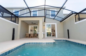 Enjoy a screened private pool with a BBQ grill and comfortable outdoor furniture, perfect for relaxing and dining al fresco.