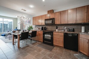 Full kitchen with an assortment of appliances, cookware, dinnerware, glassware