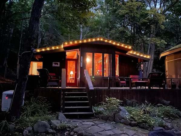 The cabin at dusk in the woods. 