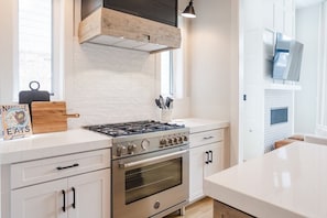 Custom Range Hood and Gas Stove - Unleash your inner chef in the gourmet kitchen at The Savant Nashville. Featuring a custom range hood and gas stove, it's the perfect setting to cook up culinary delights. Your luxury escape awaits!