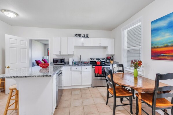 New kitchen with plenty of counter space, dishwasher.  Gather in the kitchen with seating at the counter and kitchen table.  The kitchen opens onto a cute covered patio.