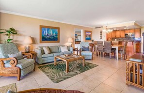 This stylish open-concept living space features comfortable seating, elegant decor, and an ocean-view dining area, making it the perfect retreat after a day at the beach.