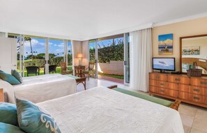 Wake up to breathtaking ocean views from this airy, sunlit bedroom with direct access to a private patio and tropical garden.