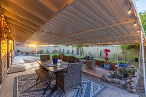 Outside dining under giant covered patio, lined with party lights.