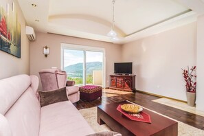 Salle de séjour avec coin TV et sortie sur le balcon