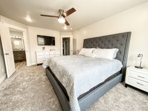 Bright and elegant king suite with plush bedding, smart TV, and private en-suite bathroom.