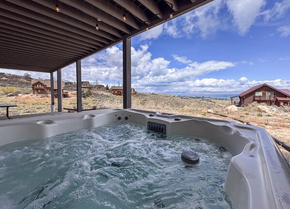 Luxurious hot tub with stunning mountain and lake views, perfect for relaxing and unwinding.