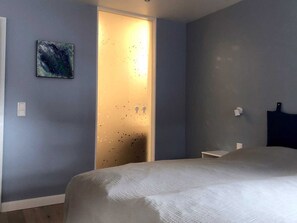 Schlafzimmer mit Glaselement zum Bad