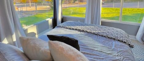 The huge bay windows in the front of the bedroom have room-darkening shades that go from floor to ceiling, ensuring your beauty rest will not be interrupted, regardless of the time you wake up.#elevatehospitality#stayCOS#staycoloradosprings#visitcolor