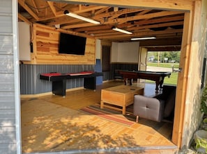 The game room with shuffle board, pool table, ping pong table, and air hockey!