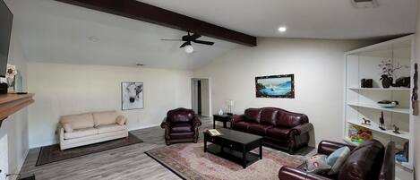 Family Room with wood burning fire place , luxury couches and a sofa bed. 