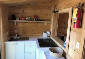 Kitchen w/ stove and mini fridge.