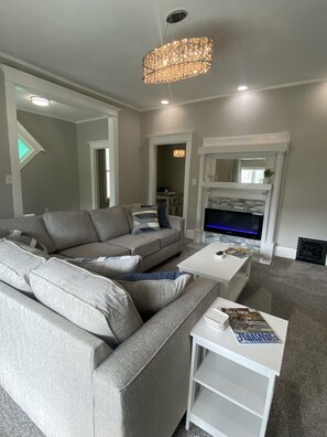 Living room with illuminated electric fireplace.