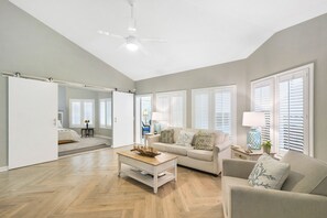 Sunlit Living Room off the Flex Space - This light-filled living area sits just off the flex room and opens to the backyard deck. It’s the heart of the home—just a 3-minute walk from Southern Soul BBQ and close to Ocean Motion bike rentals for beach days made easy.