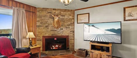 Living room bliss: Comfy couch, recliner, fireplace warmth, and a smart TV for movie magic.