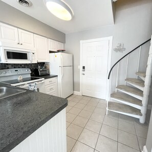 Kitchen is stocked with dishes, pots, pans and utensils.