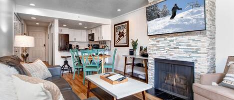 Cozy space with fireplace, sofa, dining table, and entertainment options.