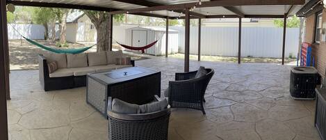 Large patio with party lighting, seating area, fireplace and games. 
