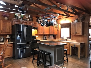Open area kitchen with sit-around-island and large butcher block.